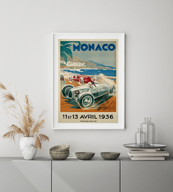 a silver vintage race car seen in a curve with pastel colors. Monaco in blue text and the Monaco castle in the background