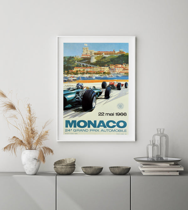 two red race cars against a Monaco city skyline and large text in blue and black. 
